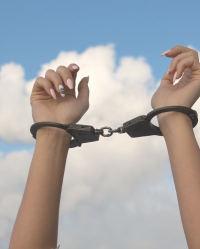 Arms raised to sky in handcuffs